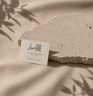 Luna Arie stone with a business card on a beige fabric background