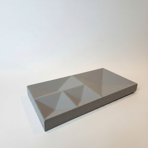 A rectangular Peak Tray Lunarie gray geometric tray with a faceted, pyramid-like pattern on top, photographed on a clean white background.