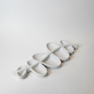 Vine Leaf Dish Lunarie Alba  with a continuous, wavy, interlocking design, arranged diagonally on a plain white background.