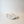 An organic shaped, wavy cement  dish in a matte off-white finish, photographed on a clean, light beige studio surface.