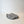 A modern, organic shaped gray cement dish or tray with a matte textured finish, photographed on a clean white studio background.
