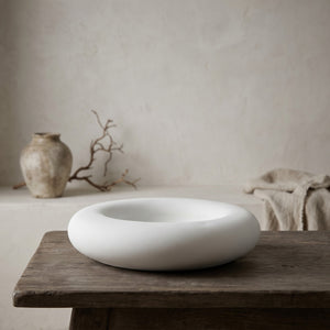 Halo Dish by Lunarie featuring a minimalist rounded design and matte finish, ideal as a jewelry catchall dish and decorative home accent. halo concrete dish on a wooden table with a neutral background