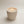 Moon Hollow Tumbler Jar by Lunarie featuring a minimalist cylindrical design with lid, ideal as a decorative storage jar for jewelry and home essentials. Candle in a beige jar with small beads on a light background