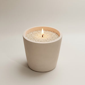 Moon Hollow Tumbler Jar by Lunarie featuring a minimalist cylindrical design with lid, ideal as a decorative storage jar for jewelry and home essentials. Candle in a beige jar with small beads on a light background