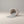 Moon Hollow Tumbler Jar by Lunarie featuring a minimalist cylindrical design with lid, ideal as a decorative storage jar for jewelry and home essentials. White concrete container spilling gray  wax sand onto a neutral background