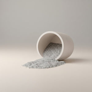 Moon Hollow Tumbler Jar by Lunarie featuring a minimalist cylindrical design with lid, ideal as a decorative storage jar for jewelry and home essentials. White concrete container spilling gray  wax sand onto a neutral background