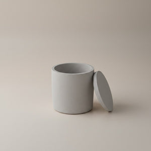 Moon Hollow Tumbler Jar by Lunarie featuring a minimalist cylindrical design with lid, ideal as a decorative storage jar for jewelry and home essentials. Gray concrete jar with lid on a beige background