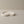 Moonlit Arc Tray by Lunarie featuring an elegant organic shape and minimalist matte finish, ideal as a decorative catchall tray for jewelry and home décor. White, wavy concrete dish on a beige surface with a plain background