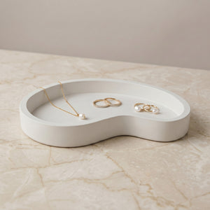 Moonlit Arc Tray by Lunarie featuring an elegant organic shape and minimalist matte finish, ideal as a decorative catchall tray for jewelry and home décor gold necklaces and rings on a marble surface