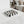 Noir Blanc Checkered Trinket Dish by Lunarie crafted from natural marble with a black and white checkered pattern and wavy sculptural design.  on a marble surface with jewelry, in a bedroom setting.