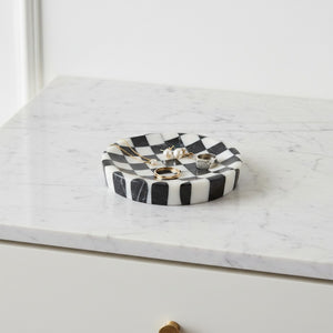 Noir Blanc Checkered Trinket Dish by Lunarie crafted from natural marble with a black and white checkered pattern and wavy sculptural design  on a marble surface with jewelry inside.