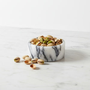 Noir Blanc Vein Marble Bowl by Lunarie filled with pistachios on a white marble surface