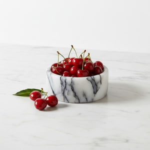 Noir Blanc Vein Marble Bowl by Lunarie crafted from natural white marble with black veining  filled with cherries on a white marble surface