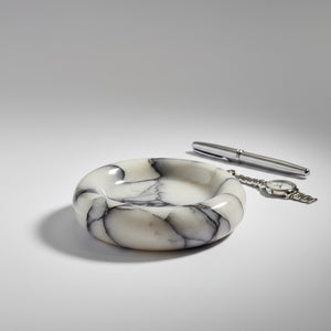 Noir Blanc Vein Marble Trinket Dish by Lunarie made from natural white marble with black veining, Marble-patterned dish  with a pen on a gray background