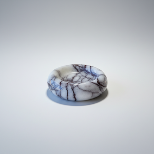 A polished noir blanc small bold veins dish, resembling a marble band, centered on a light gray gradient background.