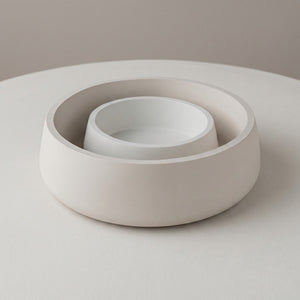 Set of two beige concrete bowls on a light gray background